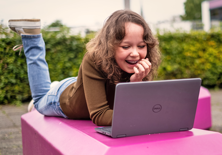 Kind lacht met beeld op laptop